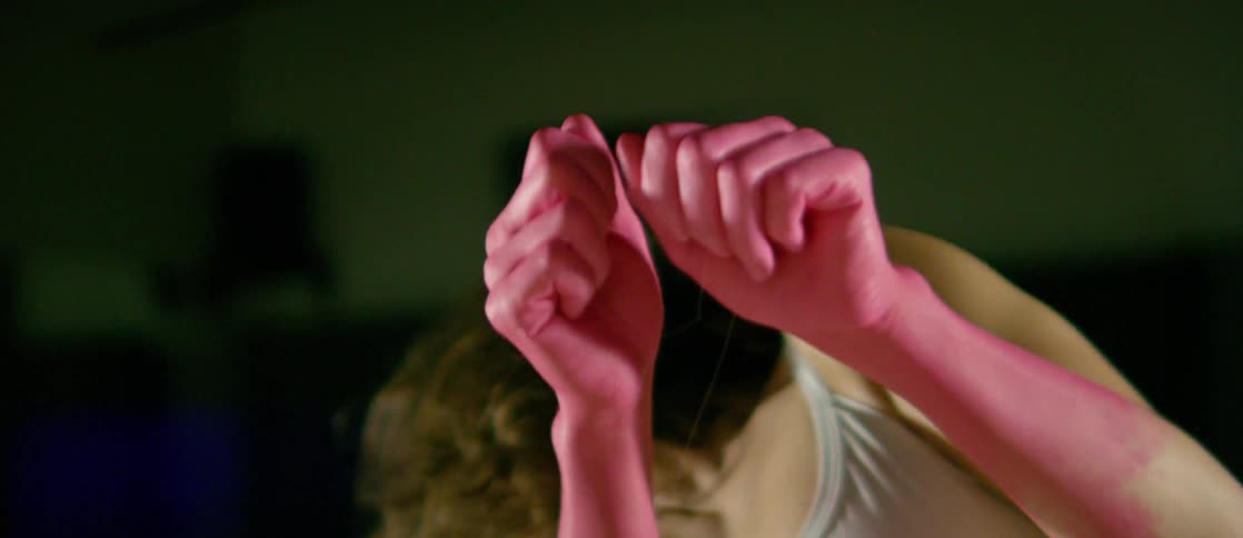 A woman with dyed red hands shakes her hair around