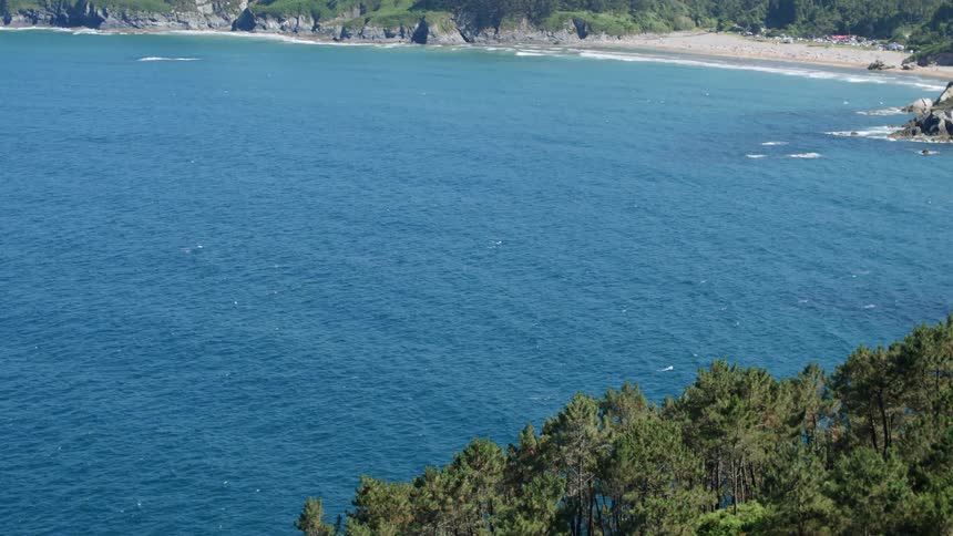 The deep blue ocean splashes the white beach