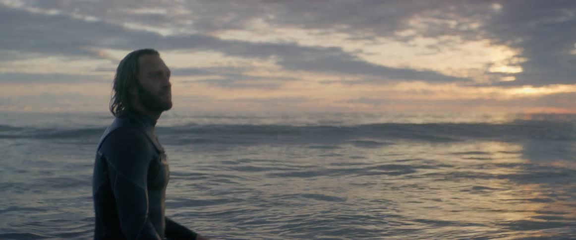 A man sitting on his surfboard in the sea