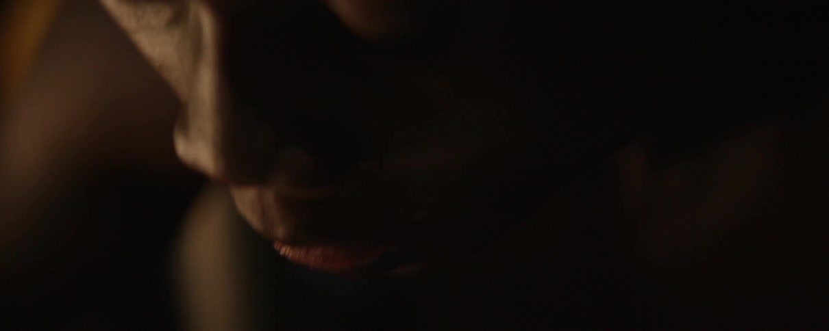 A man chews and then shovels more food into his mouth with a utensil
