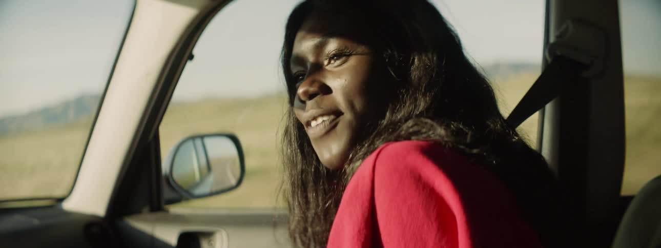 A woman smiling and laughing while riding in a car
