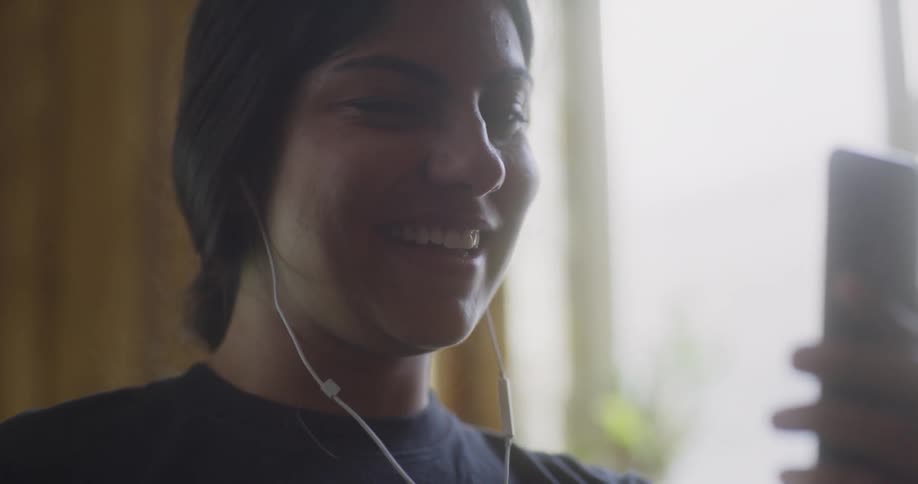 A female laughing while looking at her phone