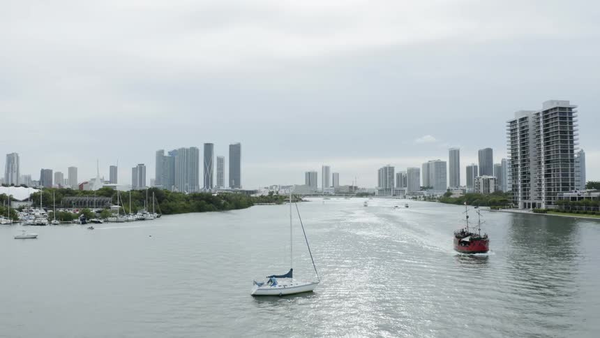 Multiple boats sailing along a canal in the city