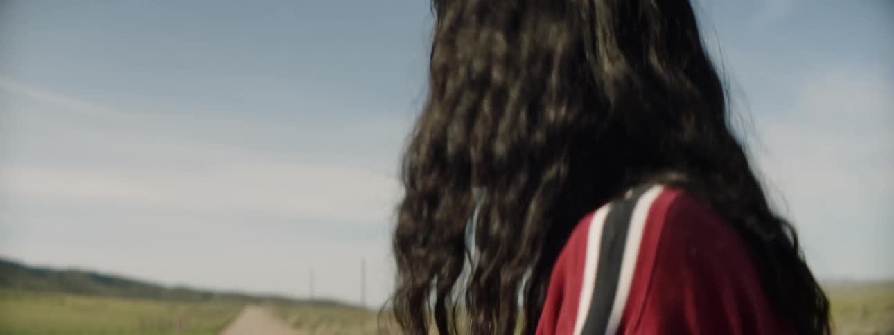 Two women argue on a country road on a sunny day