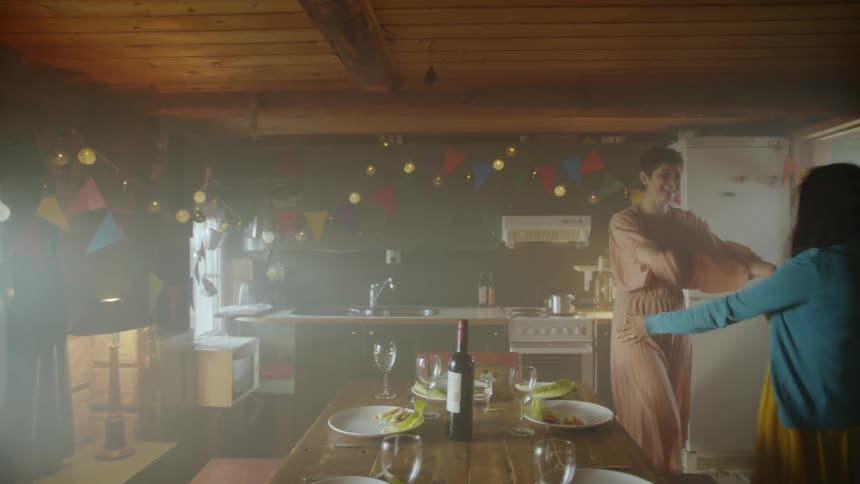 Three women walk into a room decorated for a party and hug another woman who was waiting for them
