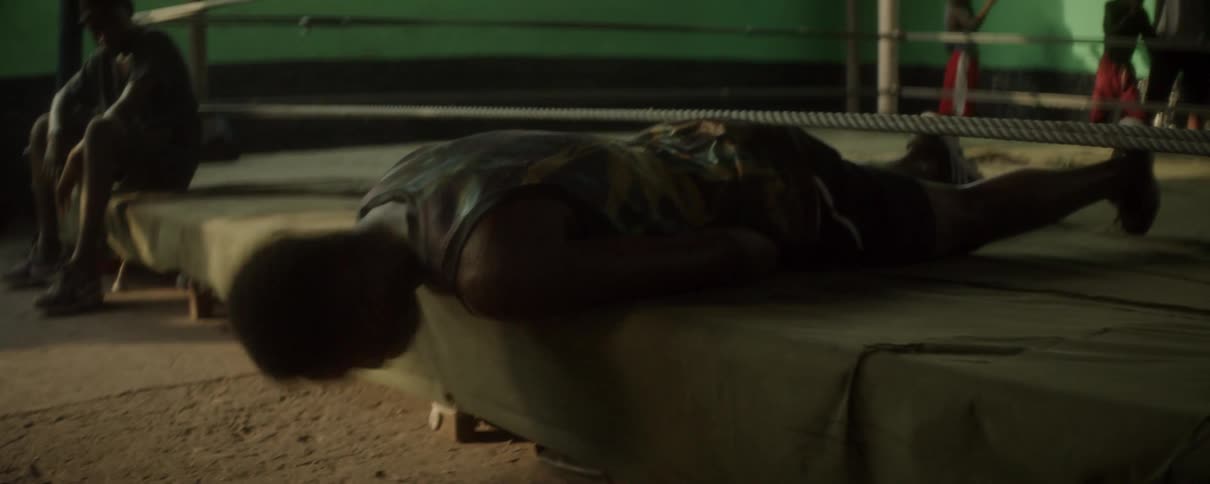 A man knocks his head against the outside of a boxing ring
