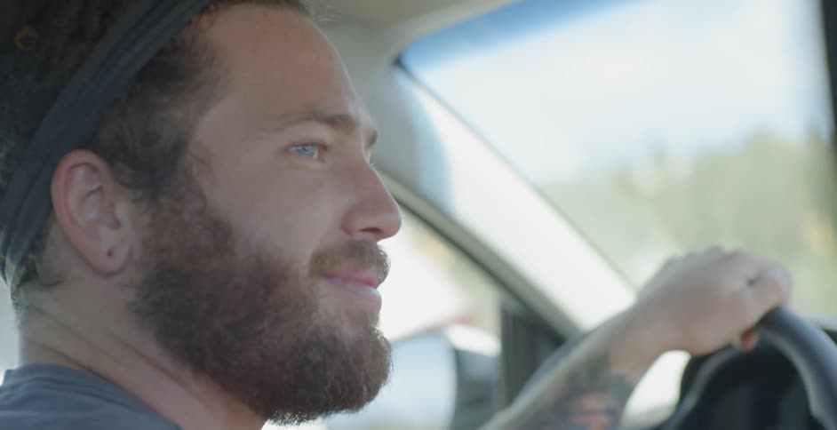 A man driving a car smiles