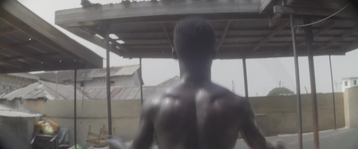 A man jumping rope in a backyard near a shed