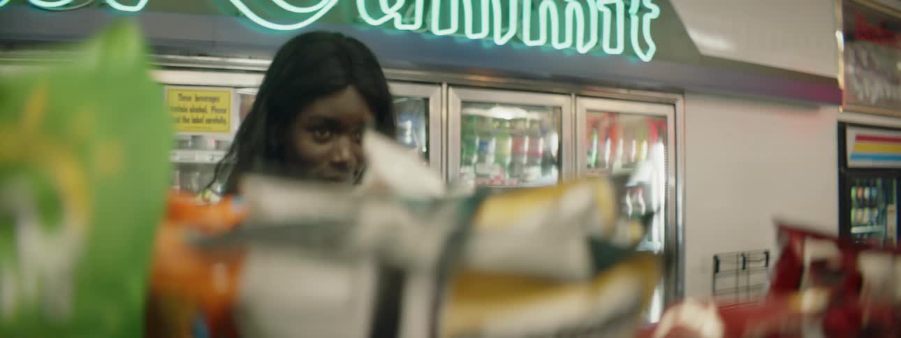 A female picking out items from a store shelf