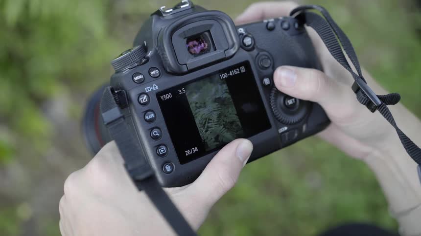 Woman flipping through photos and settings on a digital camera