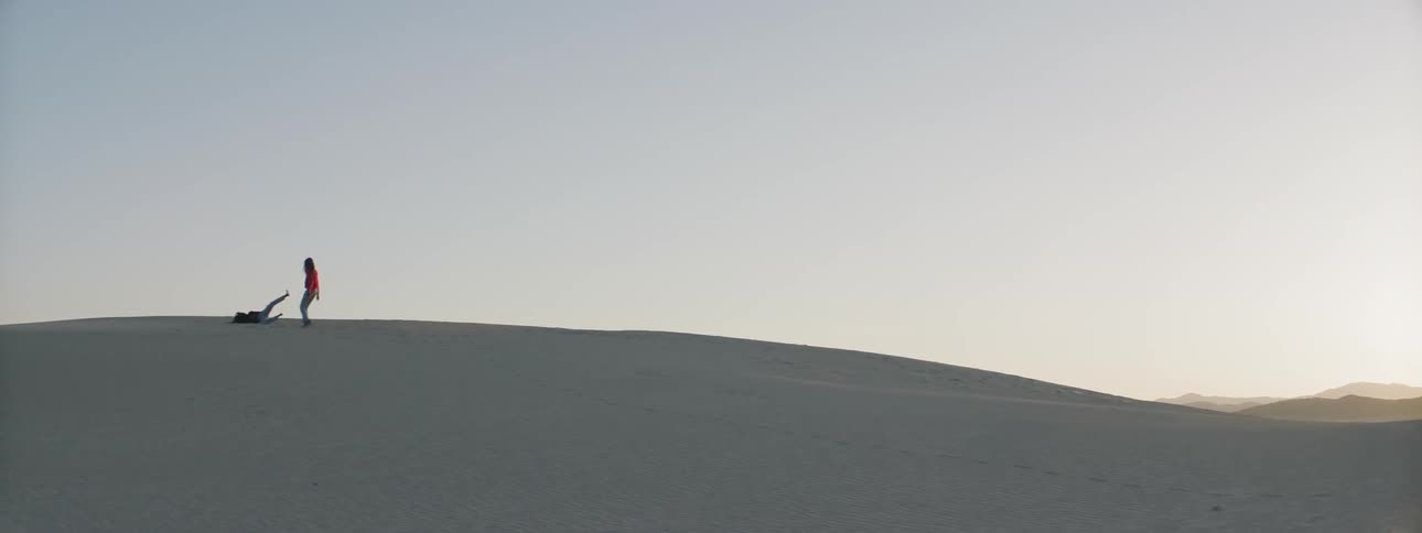Two women run and play in the desert