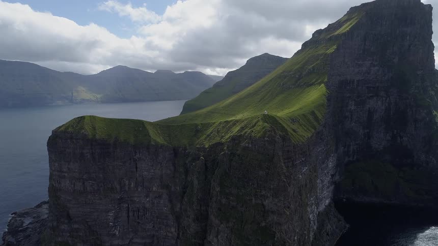 A large island made of rocks stands in the middle of an ocean