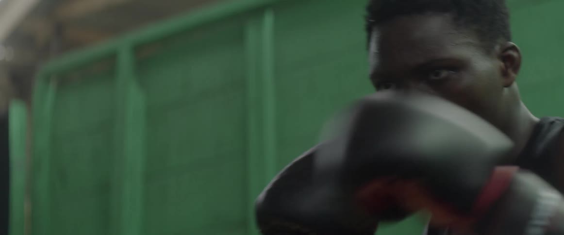 Man practicing boxing while wearing gloves