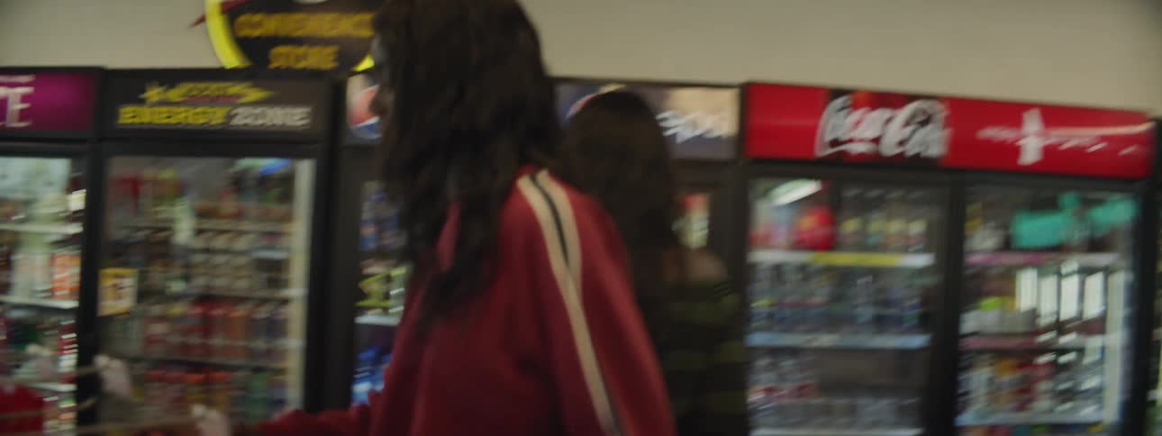 Two people looking around a convenience store looking for items