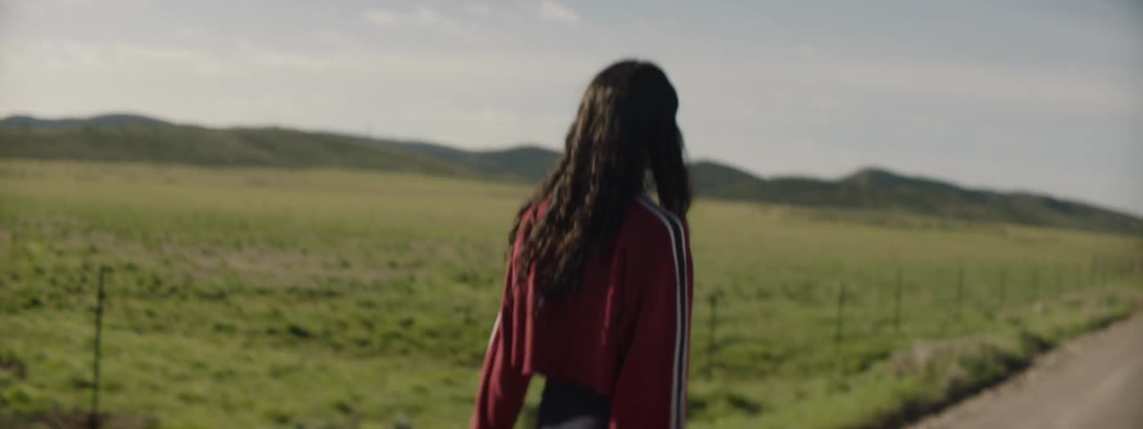 A woman angrily flips of another woman in a field