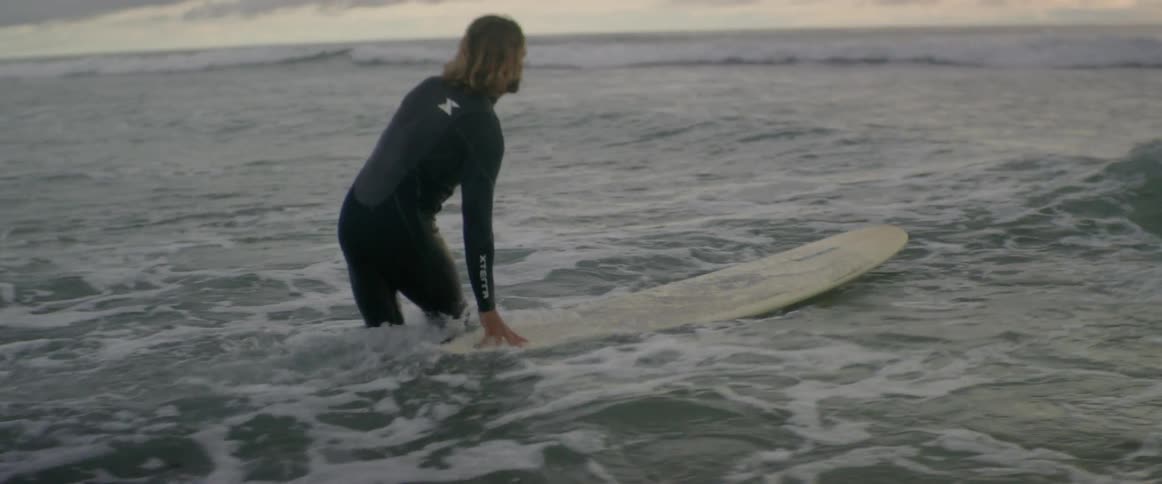 Surfer pushing his surfboard through the waves