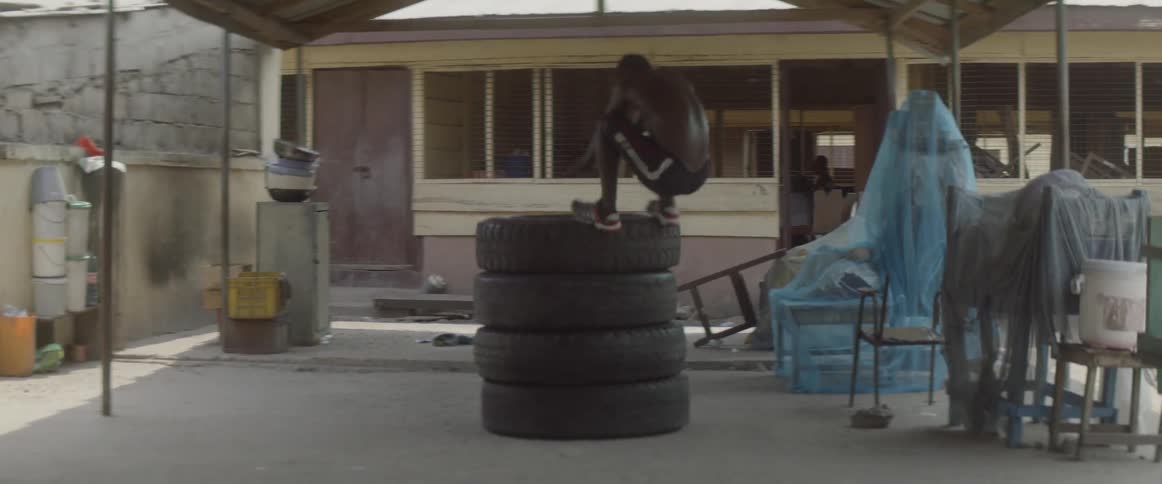 A man jumps onto a stack of tires