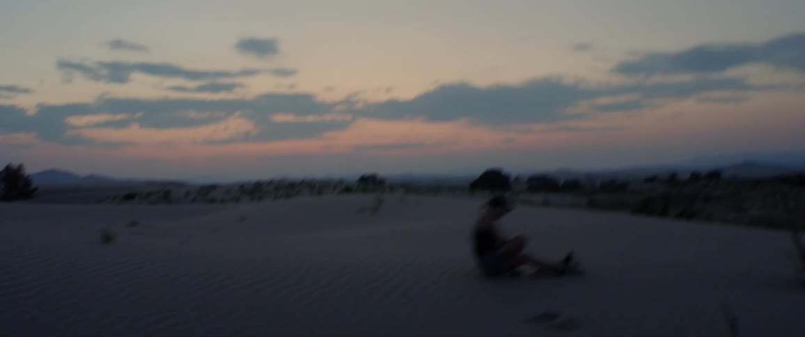 A woman that is running and jumping through the sand dunes