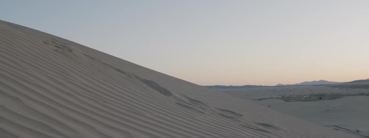 Person running down a sand dune