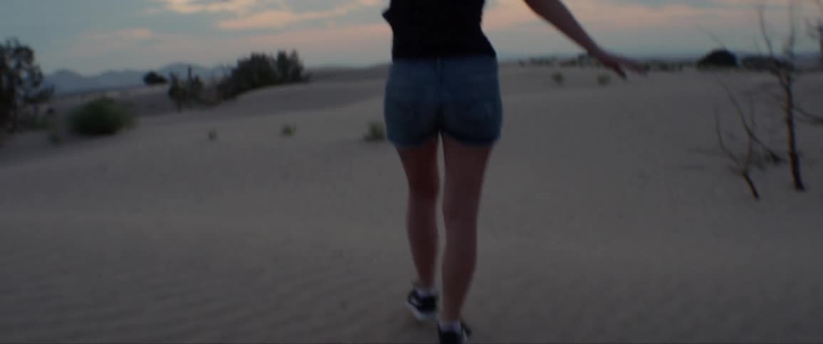 A person walking along the sandy beach