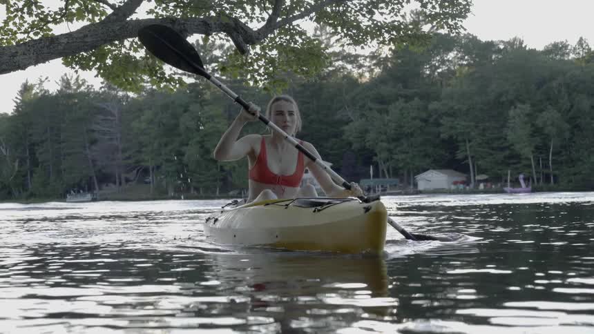 Woman paddling a canoe down a river