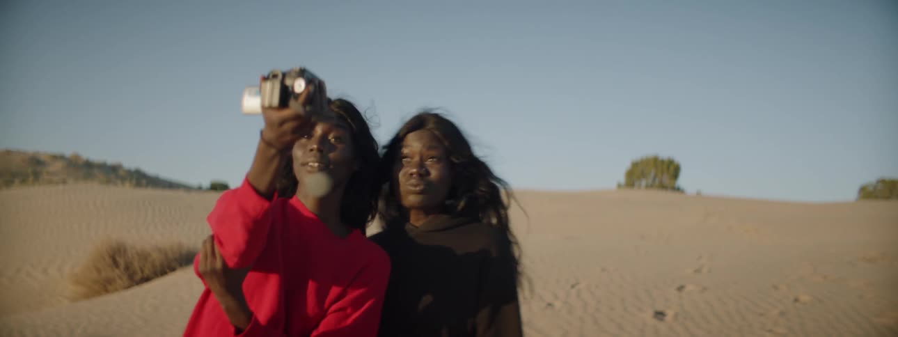 Two women film themselves as they mess around in the desert