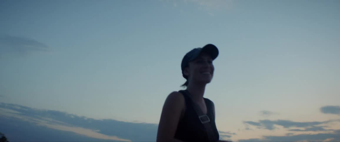 A woman smiles and laughs while walking in the desert