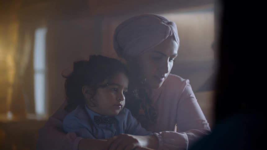 A woman holding a young child and then turns the child to cuddle