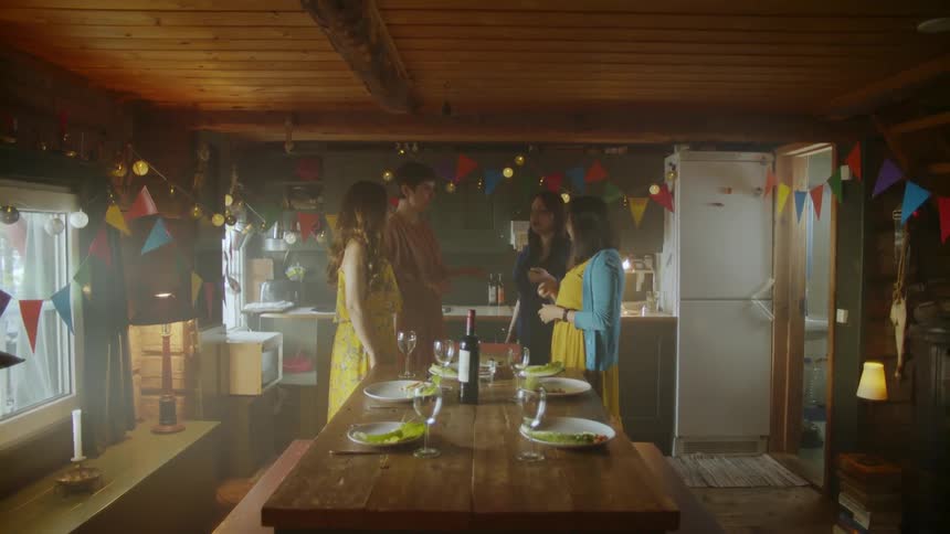 Four people stand around a table in a kitchen
