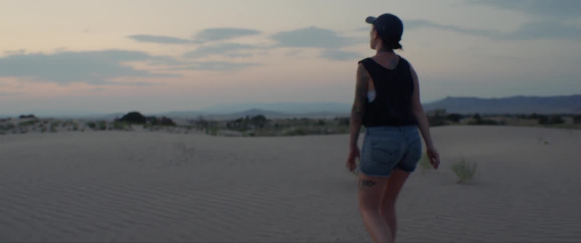 Woman Exploring Sand Dunes At Dusk