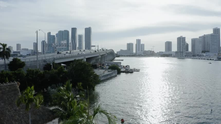 An island resort stands along an ocean that flows downstream from a city