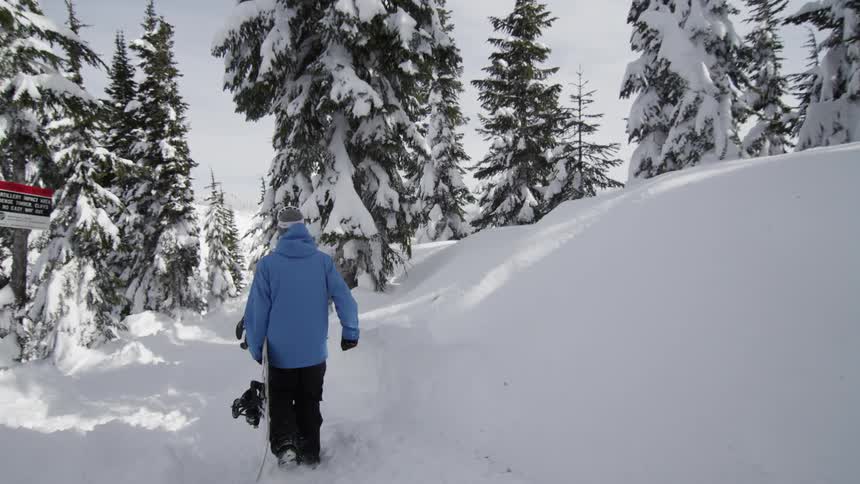A man is walking through the snow