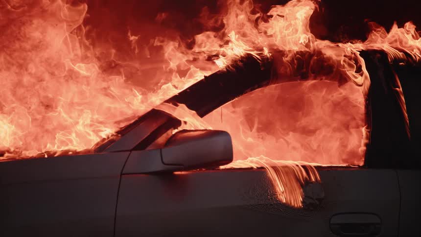 A car spews fire as it burns violently