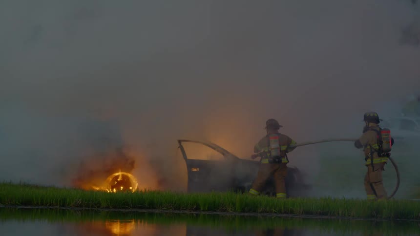 Firefighters put out a car fire
