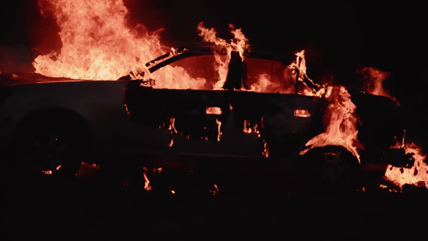 A car that is on fire and burning in slow motion