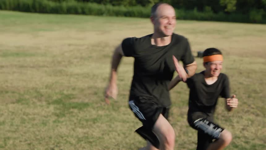 Two men are running in the grass