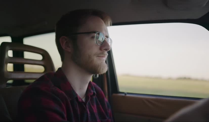 A man smiling while driving a car