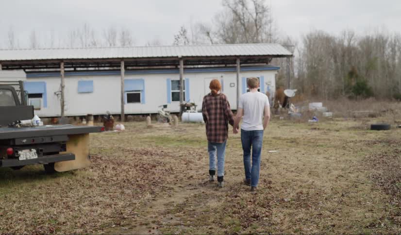A couple holding hands walking to a home