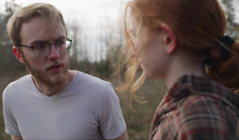A man and a woman walking in a field and talking