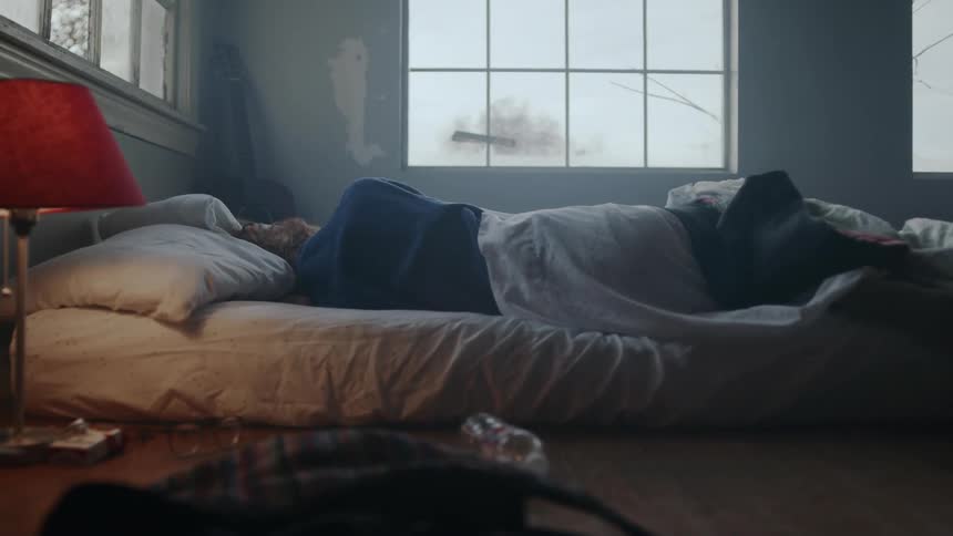 A person shift under the sheets in bed