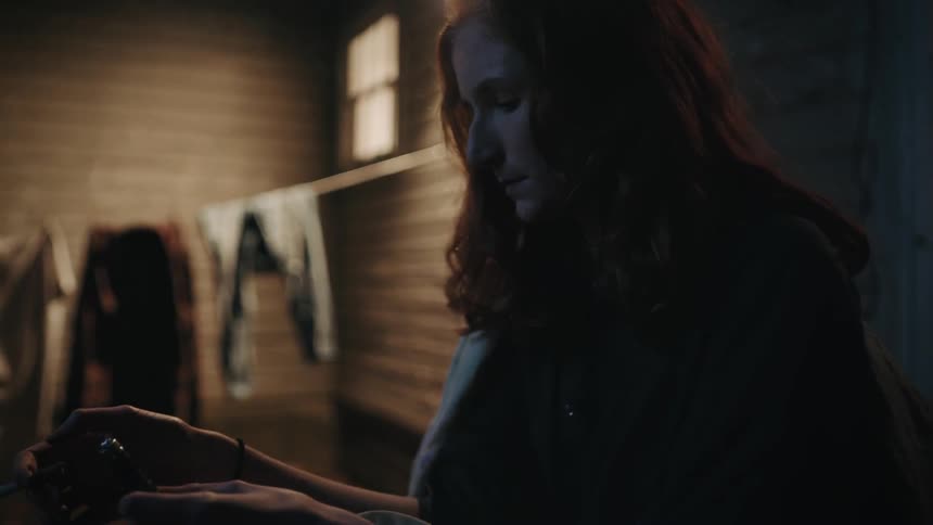 A woman is smoking while looking at her phone