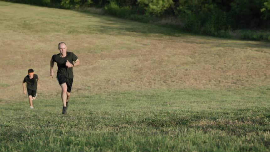 Two men are running in the grass