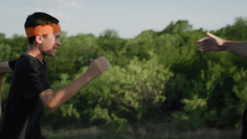 Boys are running up a hill and accepting one another after they do