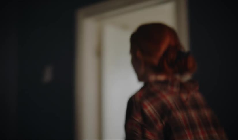 A woman looking out a window then running through the house