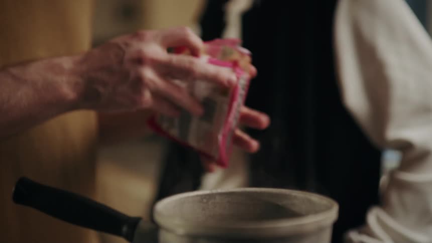 A man opens a pack of instant ramen