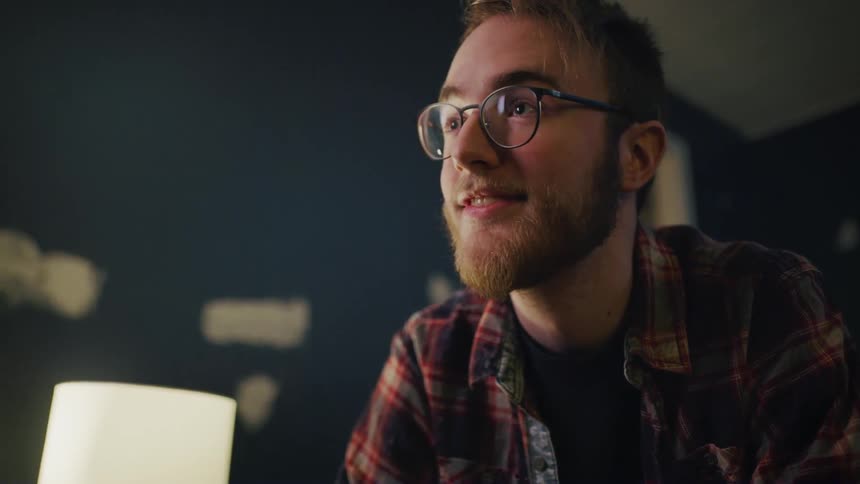 A man wearing glasses talking to someone