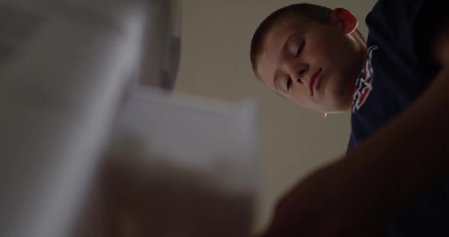 A boy is looking through drawers