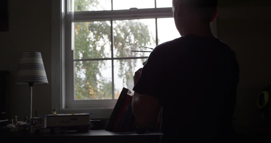 A boy is playing with an airplane