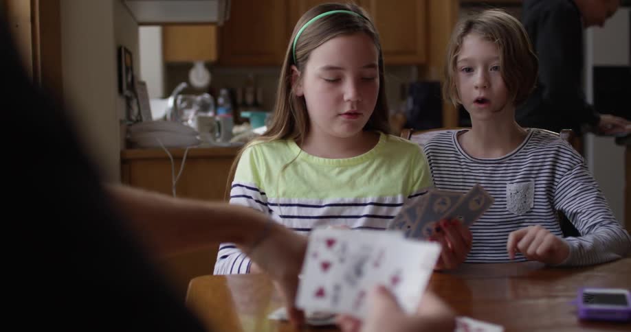 Children playing a card game at the kitchen table