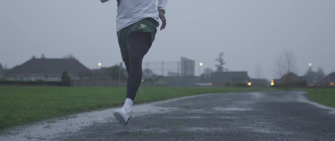 A man is jogging down the street